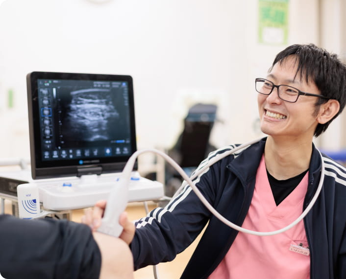 理学療法士がエコーで患者の足を診ている