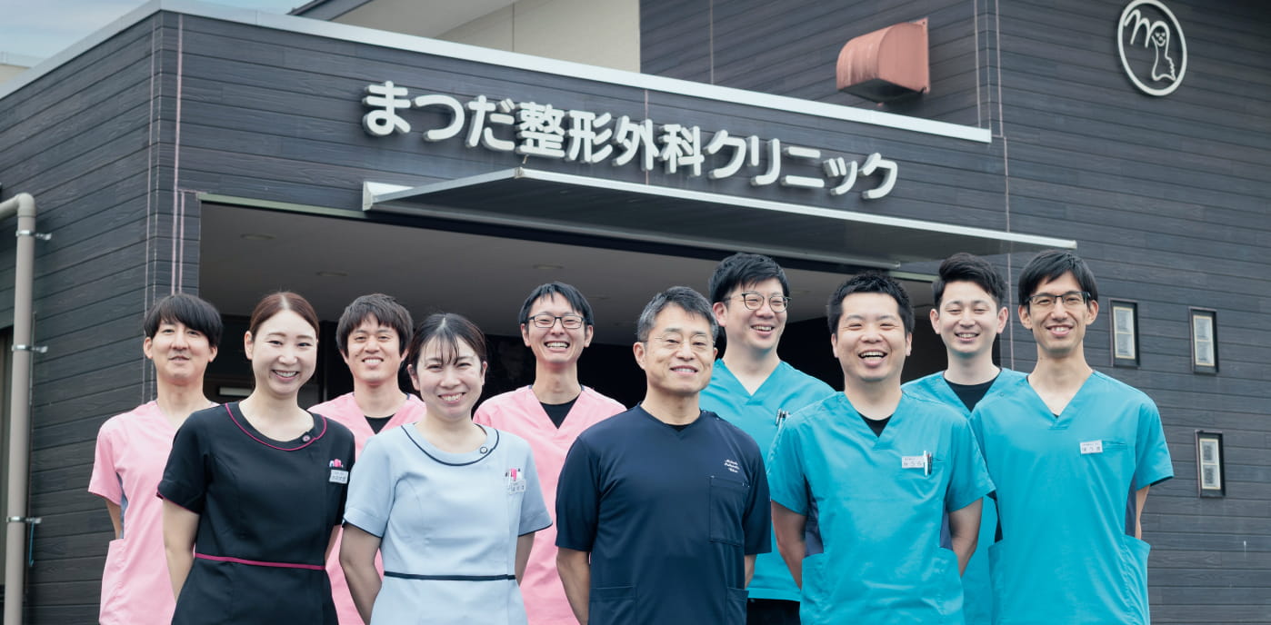 院長松田芳和と職員一同の集合写真