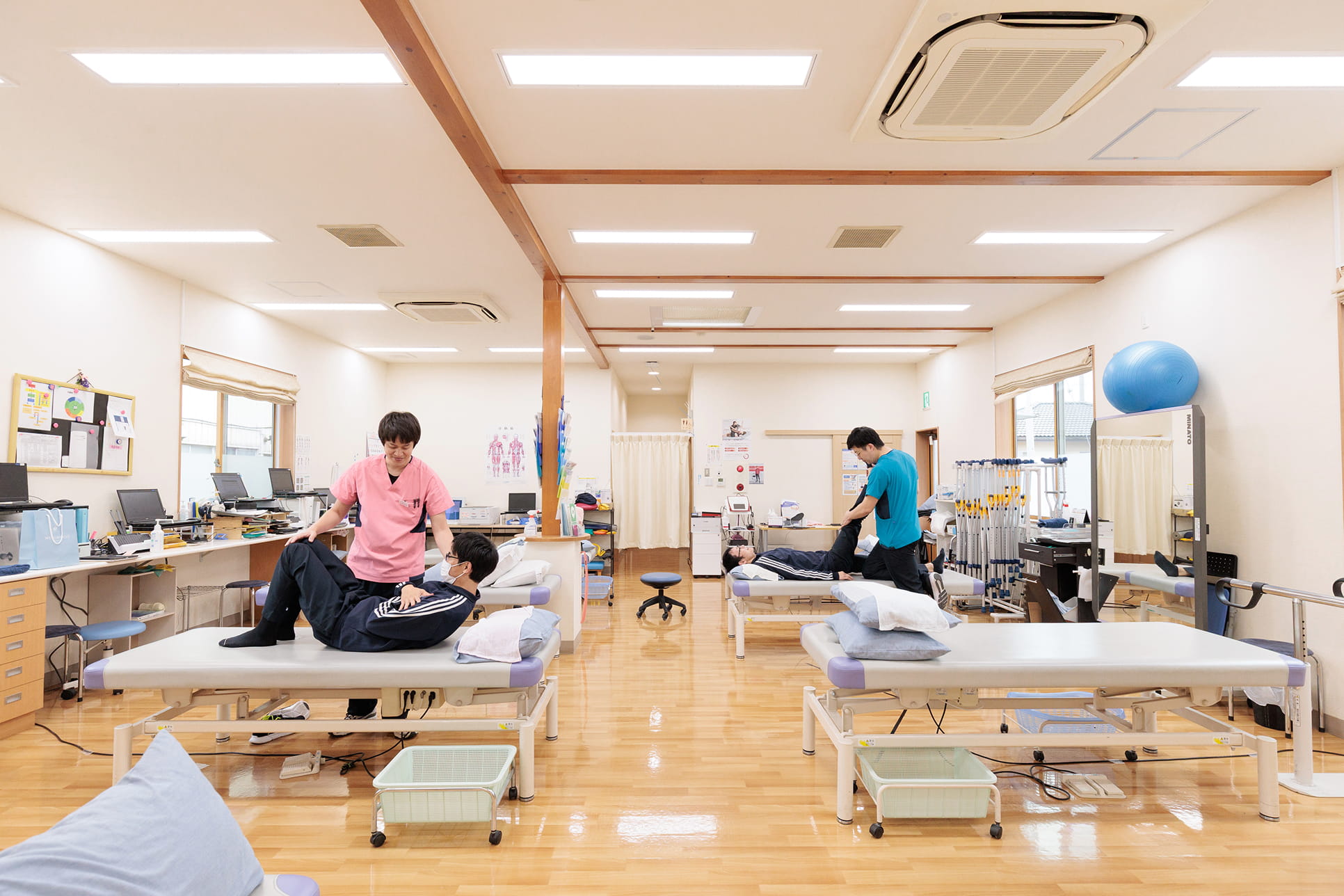 広いフロアで理学療法士とリハビリを行っている様子