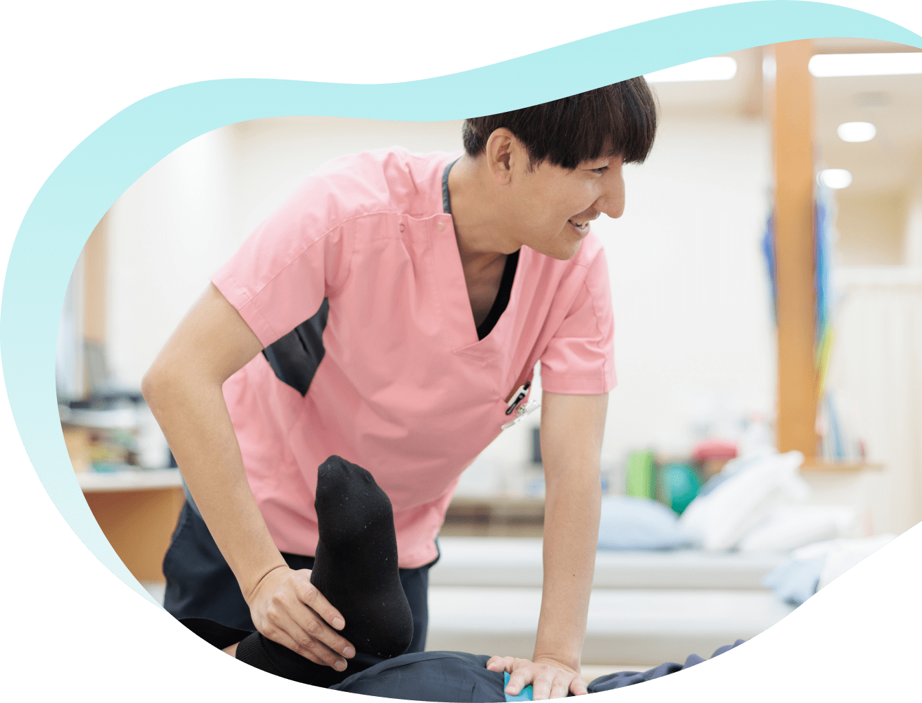 男性看護師が患者の足をストレッチしている